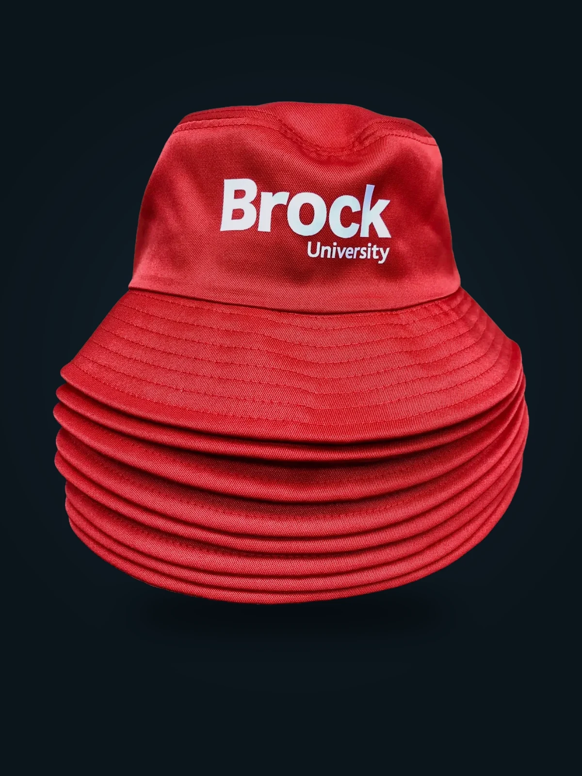 Stack of red Brock University embroidered bucket hats